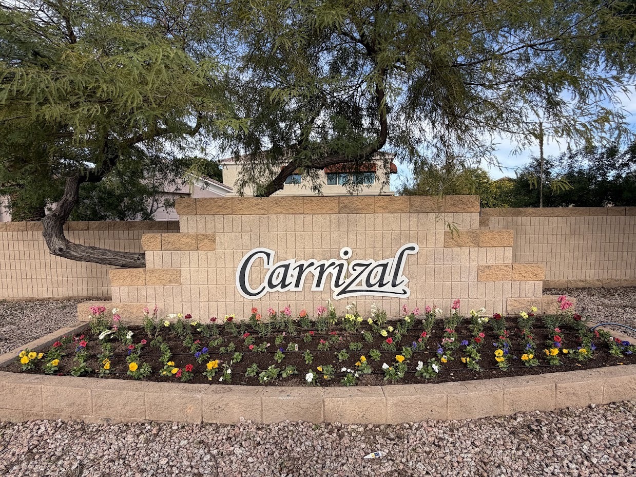 Carrizal entrance with flower bed and tree
