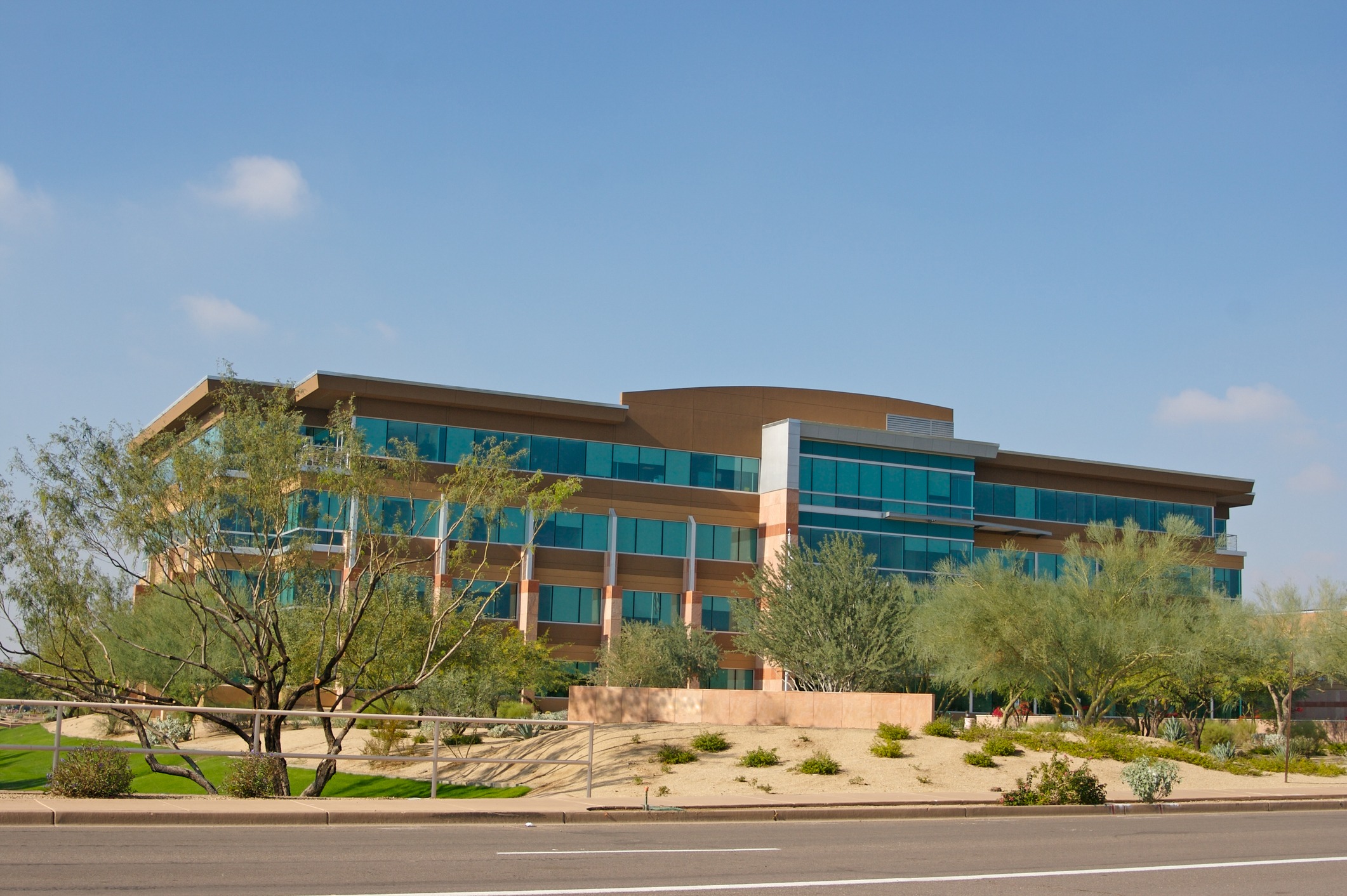 Modern office building with glass windows and trees.