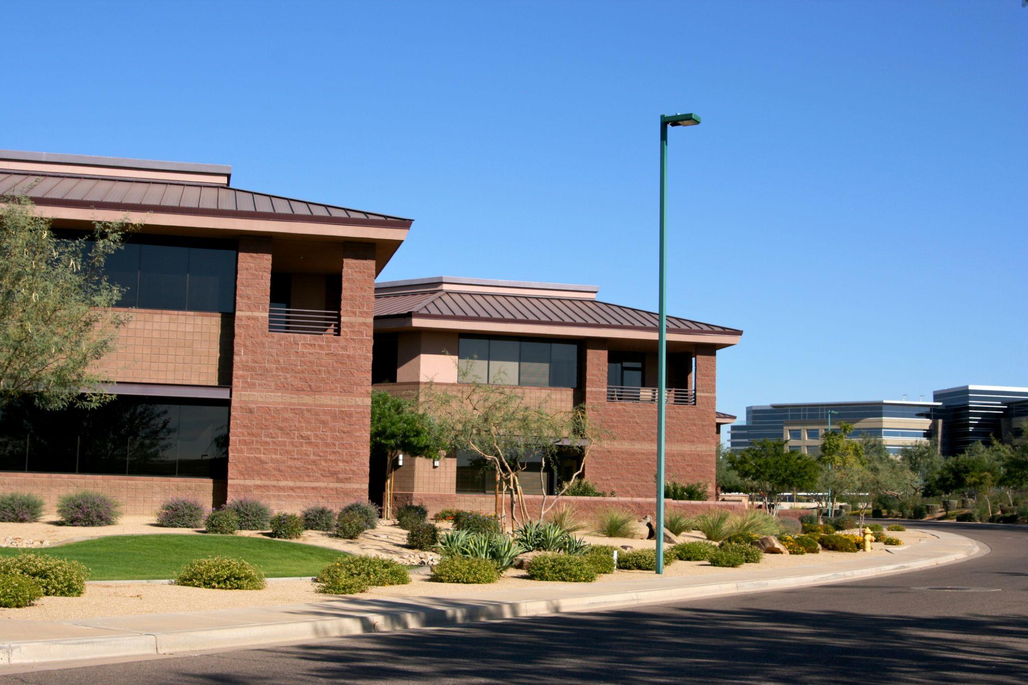 Desert-landscaped Arizona commercial building exterior with shrubs and gravel
