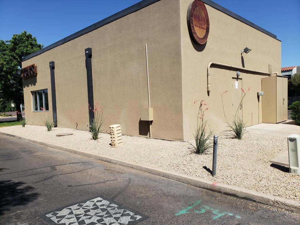 Tan stucco commercial building with desert gravel landscaping and business signage